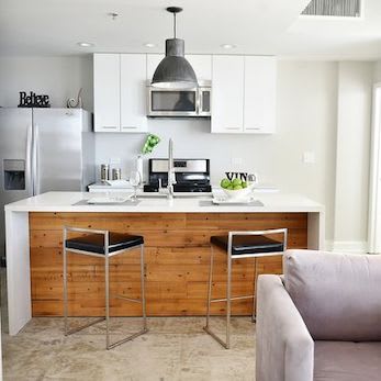 Modern kitchen with quartz island, pendant lighting, and stainless steel appliances