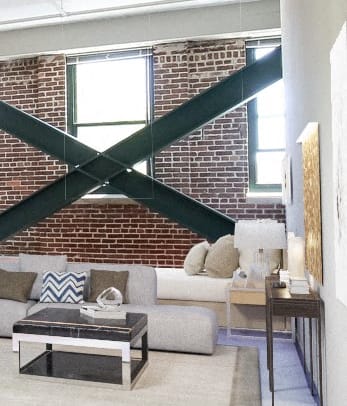 Staged unit interior. Unjt has Brick wall and exposed cross beams.
