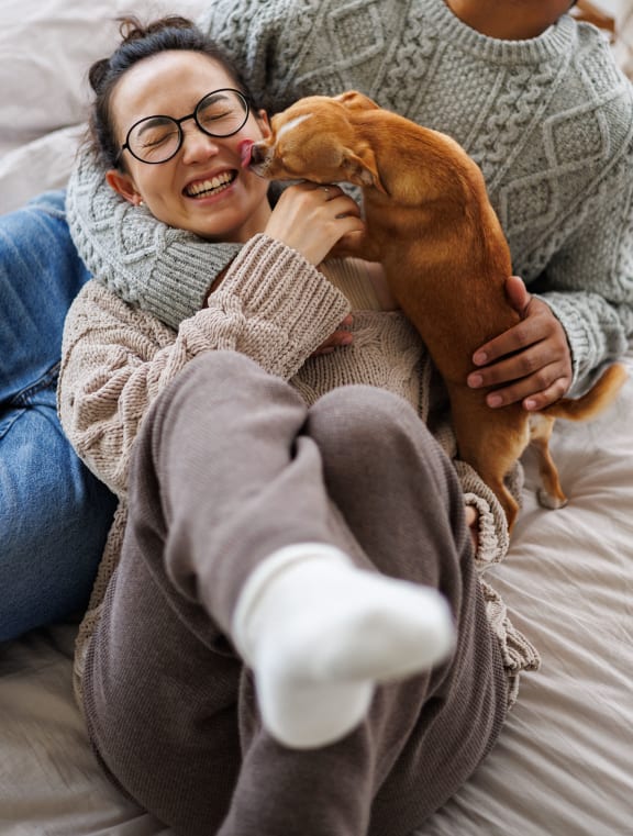 a woman laying on a bed with a dog