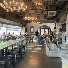 the interior of a restaurant with people sitting at tables