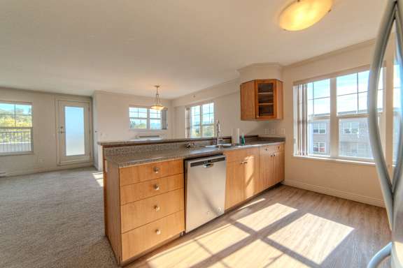 A kitchen with wooden cabinets and a large island.