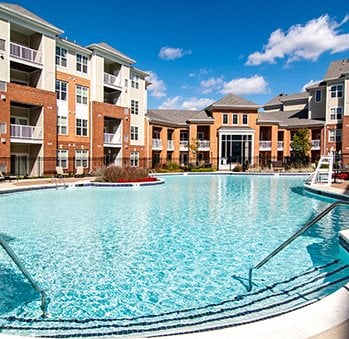 A large swimming pool in front of apartment buildings.