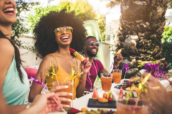 A group of people enjoying drinks and food at an outdoor gathering.