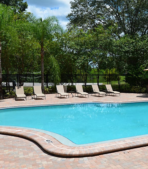 a swimming pool with chairs around it