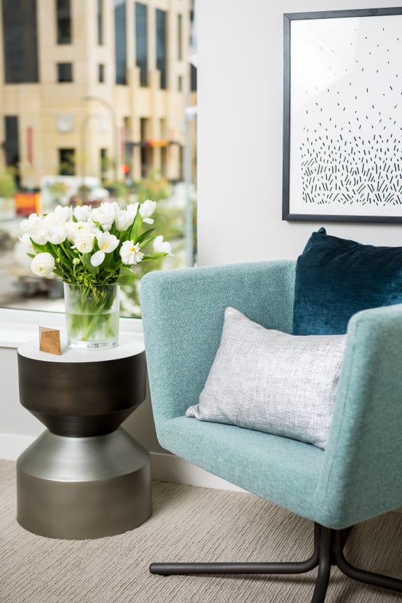 A blue chair with a coffee table at Edition Apartments. 