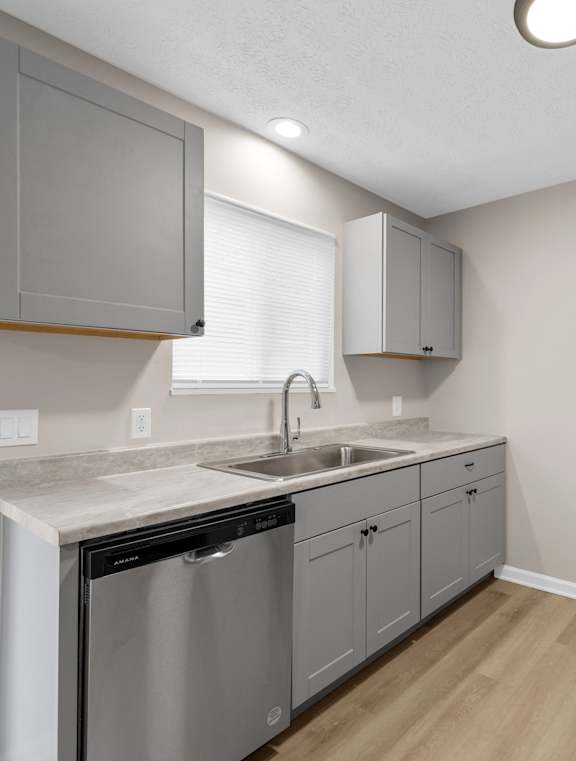 A kitchen with a black refrigerator and a white sink.