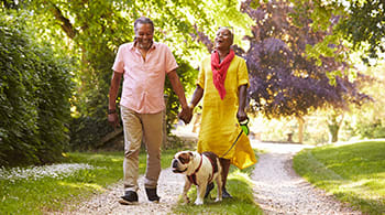 Elderly couple walking a dog