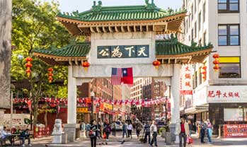 A bustling street scene with a Chinese archway entrance.