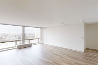 an empty living room with a large window at The Pavilion, Detroit, MI
