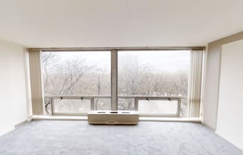 an empty living room with a large window at The Pavilion, Detroit, 48207