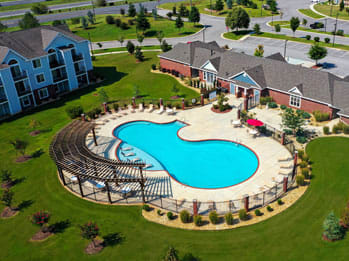 an aerial view of an outdoor swimming pool in a residential neighborhood
