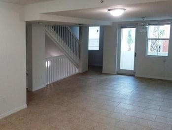 large living area with overhead lighting and large windows