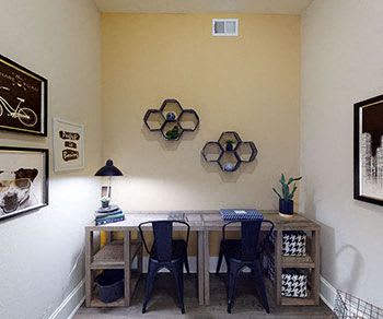 The business center with a desk, two chairs, lamps, shelves, and decorations, at Four Seasons. 