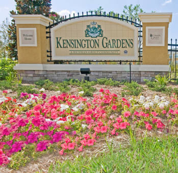 a bed of flowers in front of the kensington gardens sign