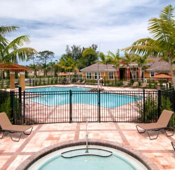 a large swimming pool with a fountain in the middle of it and houses in the background