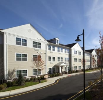 a street view of an apartment complex with a street light in the foreground