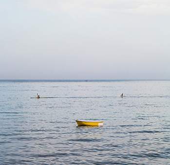 a yellow boat sitting on top of a large body of water