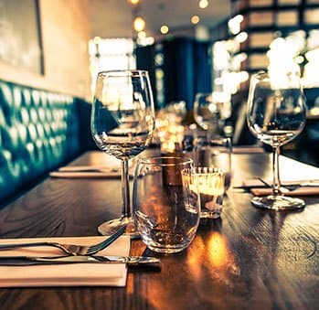 a wooden table with wine glasses on it at The Edge on the Boulevard, California