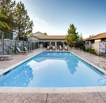 a swimming pool with chairs and a building in the background at ALTITUDE BY VINTAGE, Reno, 89523