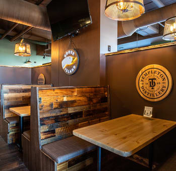 a restaurant with wooden tables and benches and a logo on the wall
