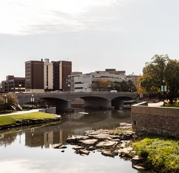 a bridge over a river with buildings in the background