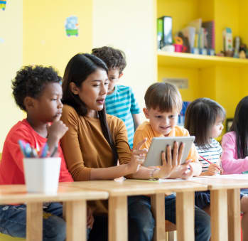 Teacher with elementary students looking at tablet at TOWNSHIP Apartments, Oregon