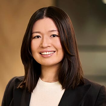 a woman with black hair and a white shirt is smiling at the camera