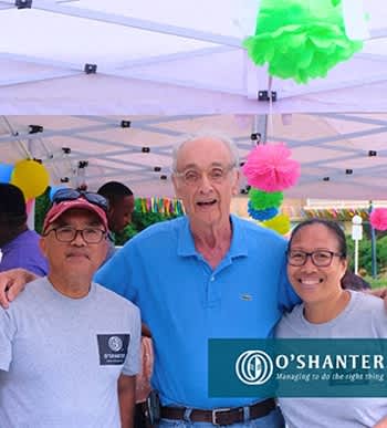 three people pose for a picture under a tent