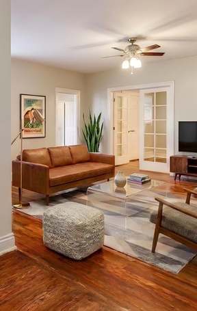 A living room with hardwood floors and a ceiling fan at Cathedral Mansions in Washington, DC 20008