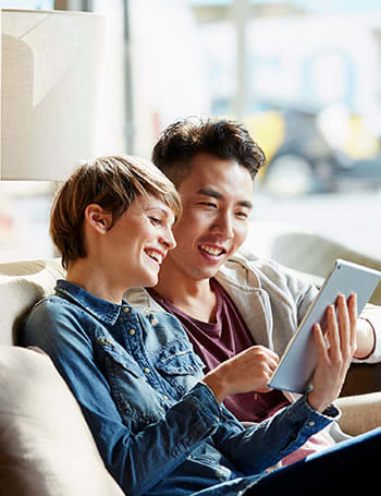 Couple sitting together looking at a tablet
