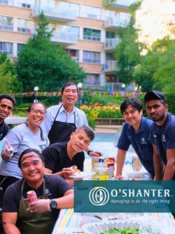 a group of people posing for a picture at a picnic table