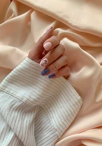 A person's hand with a ring on the middle finger, resting on a striped fabric.