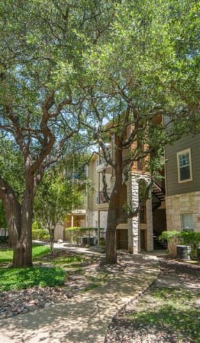 Austin TX Apartments - Exterior View of the Apartment Building Showcasing Large Community and Beautiful Landscaping