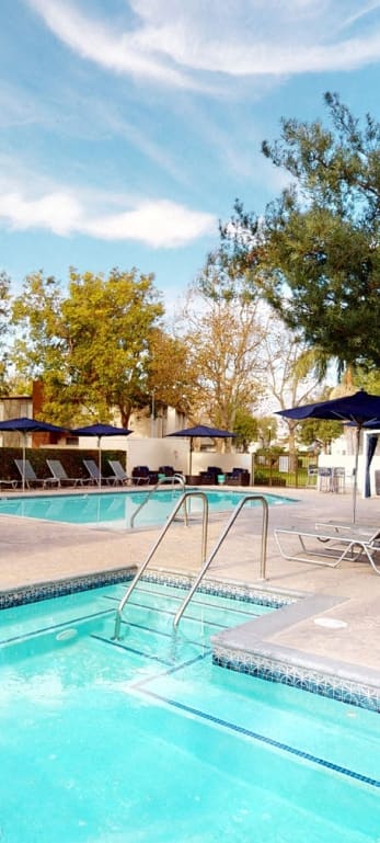 a swimming pool with chairs and umbrellas at the resort