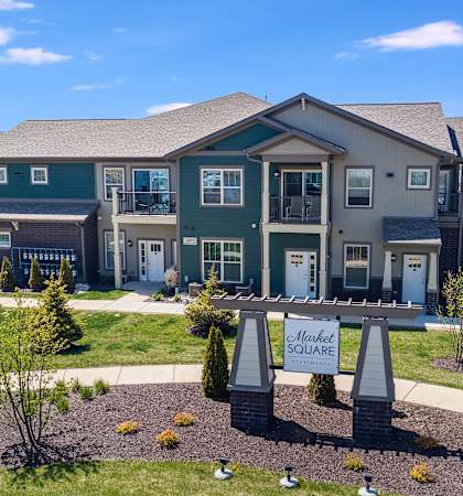 a large house with a sign in front of it on a sidewalk