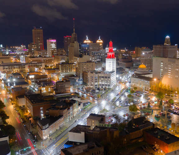 A cityscape at night with a river running through it.