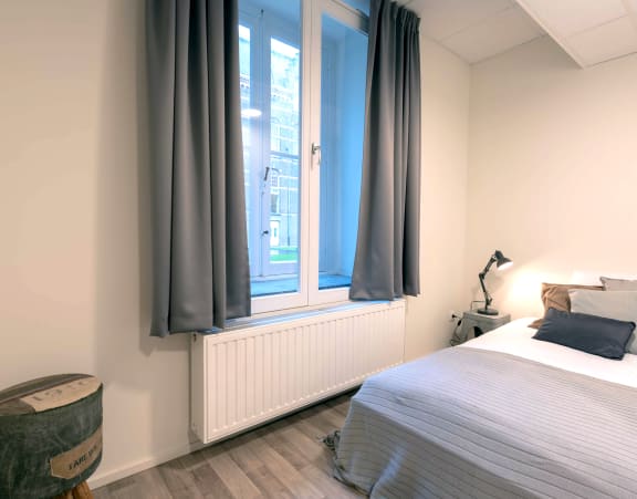 a bedroom with a bed and a window