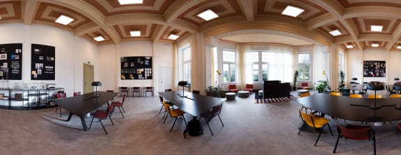 a dining room with tables and chairs in a large room with windows