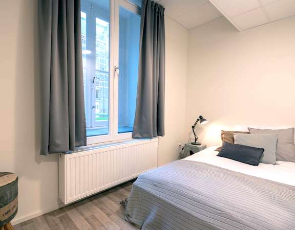 a bedroom with a bed and a window