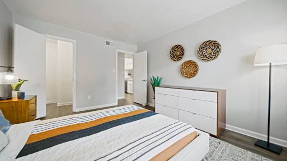 A bedroom with a bed, nightstand, and a lamp.