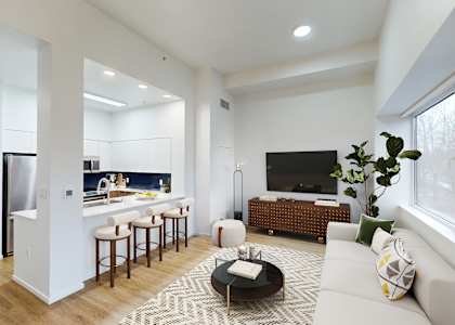 A modern living room with a bar and a kitchen in the background.