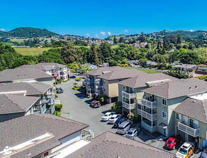 an aerial view of houses with cars parked in front of them