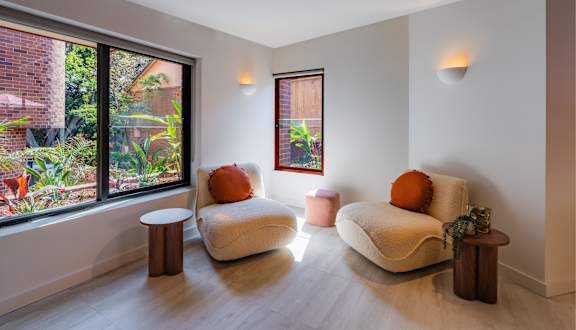 a living room with two chairs and a window
