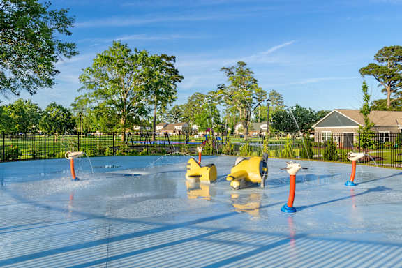 A large swimming pool with lounge chairs and a building in the background.