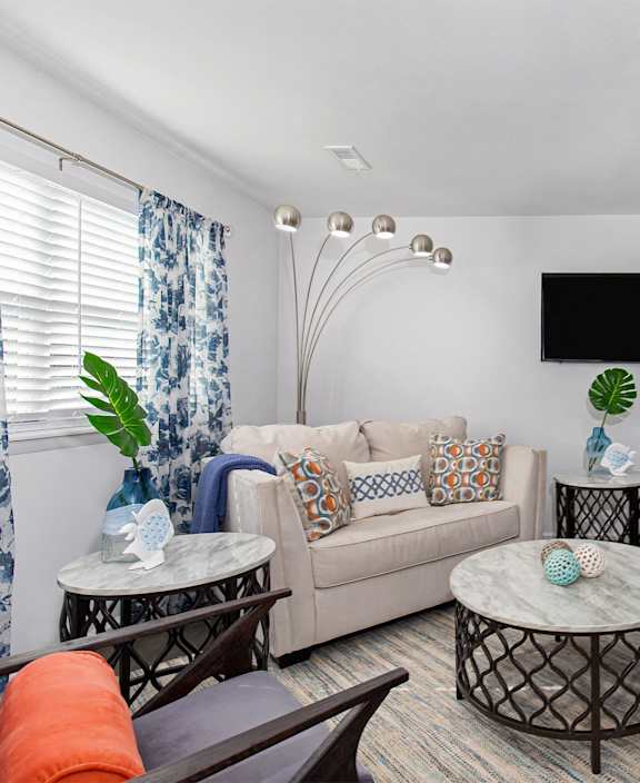 a living room with a couch and chairs and a tv