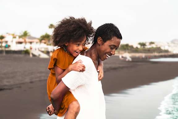 A person giving piggyback to a kid at Cobia Cove Apartments, Holiday, Florida