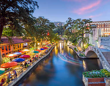 A river runs through a city with a bridge and buildings on either side.