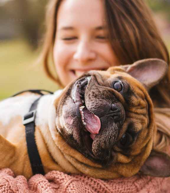 a woman holding a dog in her arms
