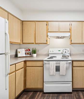A kitchen with wooden cabinets and white appliances.
