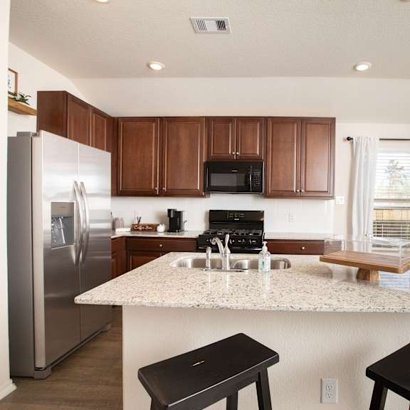A spacious kitchen with a skylight and a wooden island.